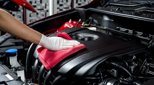 Engine bay being wiped down
